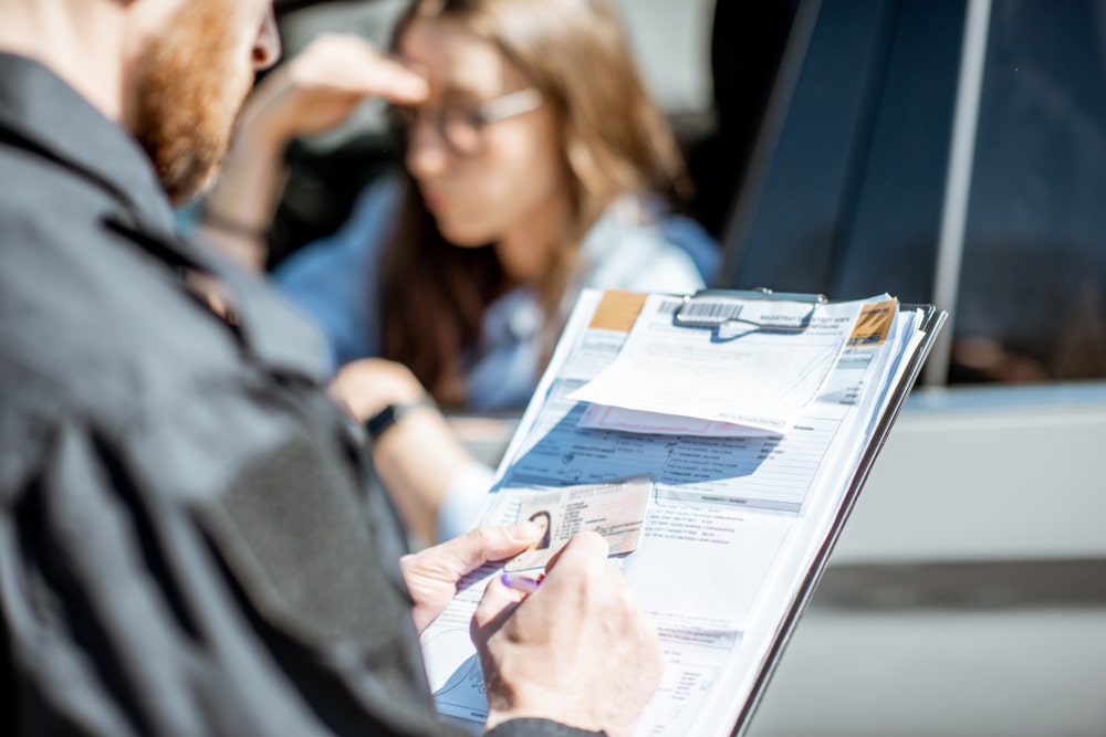 Police Officer Writing A Ticket For An Upset Driver