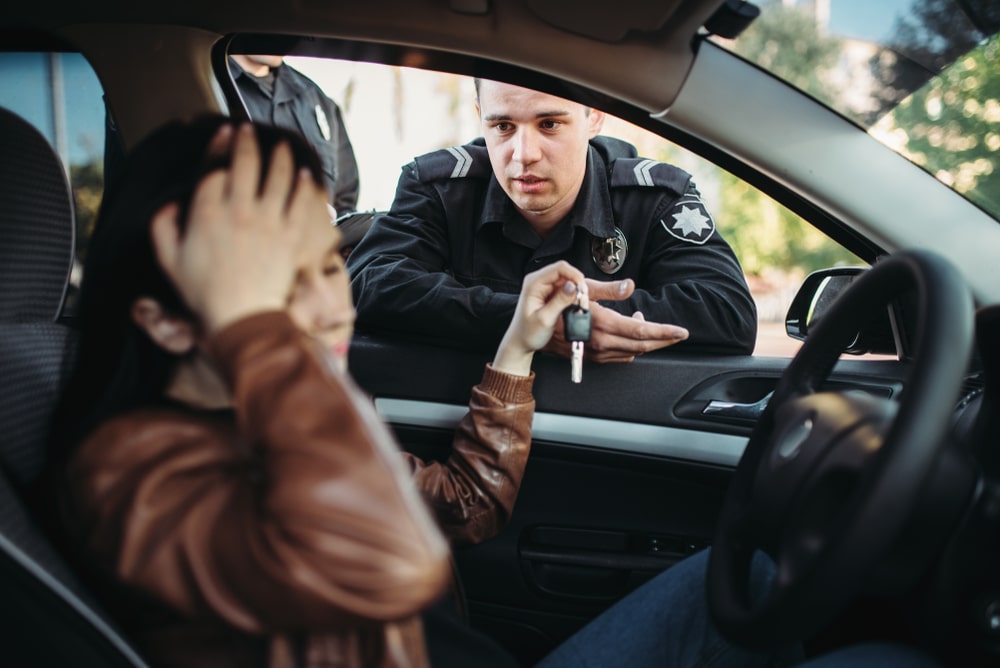 Upset Driver Handing Her Car Keys To A Police Officer