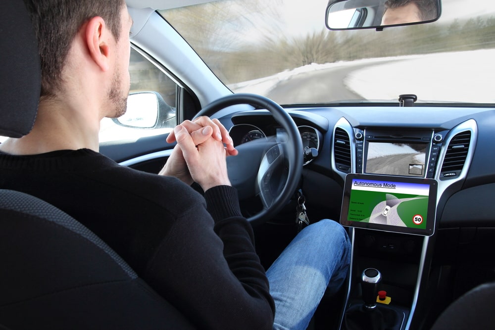 Man Riding In A Car Not Holding The Wheel