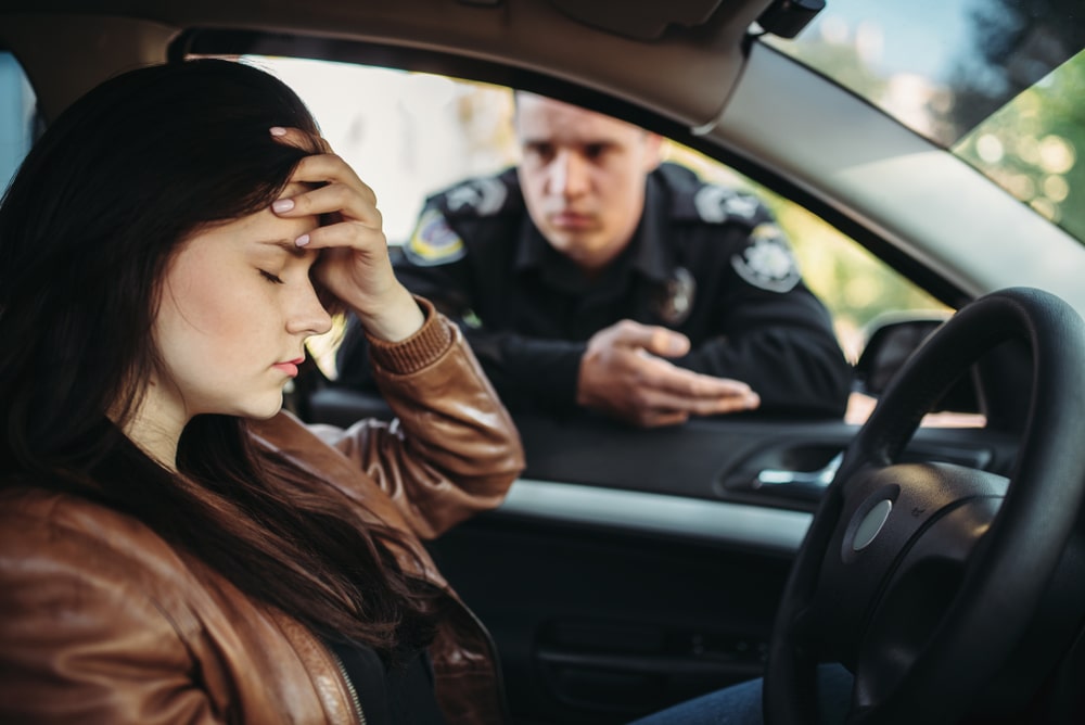 Woman Driver Holding Her Head And A Police Officer Talking With Her