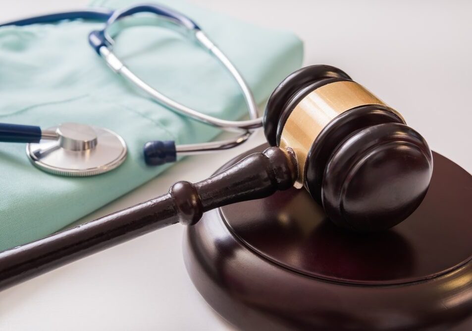 Gavel and stethoscope on table, medical law.