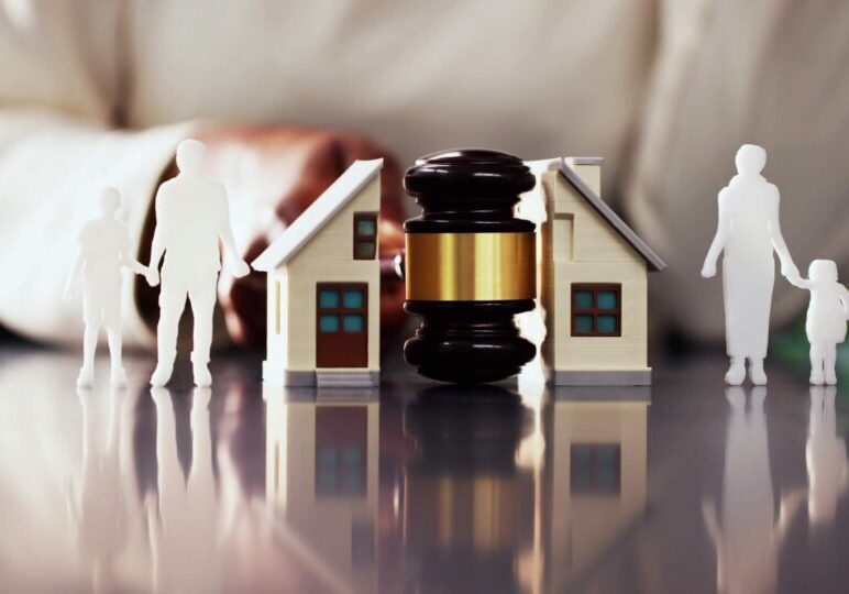 Gavel between model houses and family figures.
