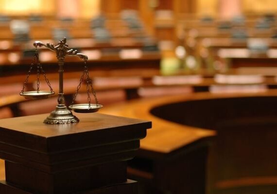 Scales of justice in empty courtroom.