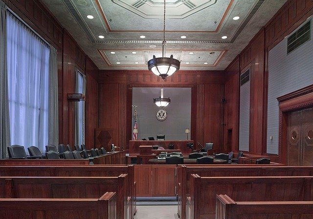 Empty courtroom with wooden interior and seating.